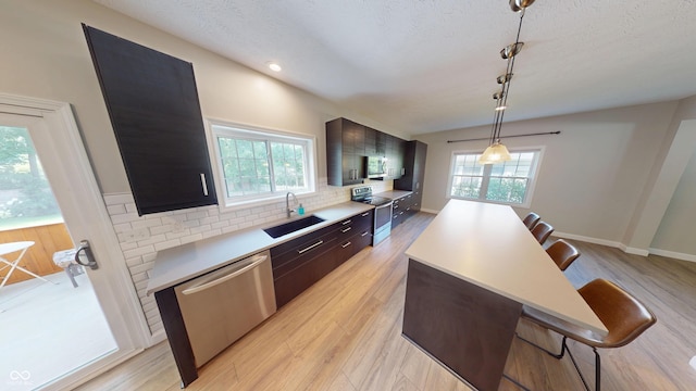 9831 Deering St, Fishers, IN 46037 - kitchen featuring stainless steel appliances, a breakfast bar area, light countertops, a center island, and tasteful backsplash