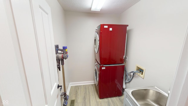 9831 Deering St, Fishers, IN 46037 - laundry area featuring stacked washer / dryer, wood finished floors, and a textured ceiling