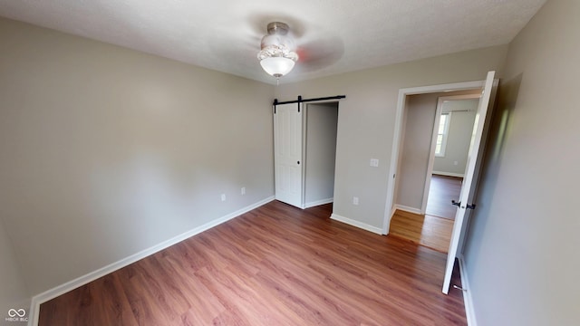 9831 Deering St, Fishers, IN 46037 - unfurnished bedroom featuring wood finished floors and a barn door