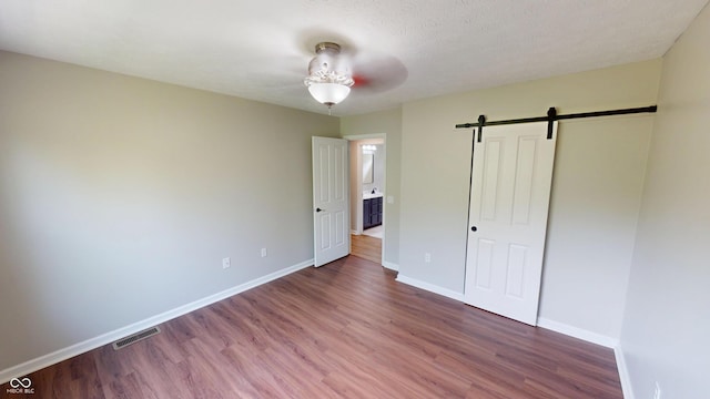 9831 Deering St, Fishers, IN 46037 - unfurnished bedroom featuring wood finished floors, a barn door, and a closet