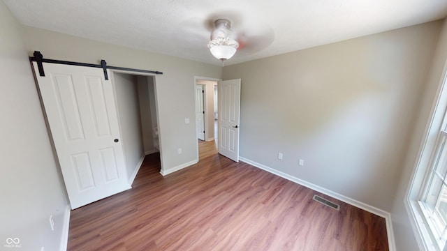9831 Deering St, Fishers, IN 46037 - unfurnished bedroom featuring light wood-style flooring and a barn door