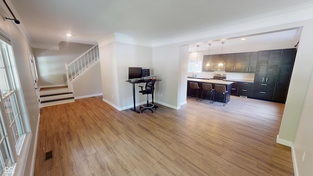 9831 Deering St, Fishers, IN 46037 - kitchen with light countertops, electric stove, light wood-type flooring, crown molding, and a center island