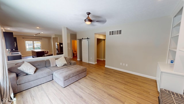 9831 Deering St, Fishers, IN 46037 - living area featuring a barn door, light wood-style flooring, ceiling fan, and recessed lighting