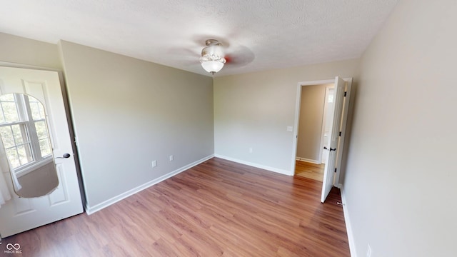9831 Deering St, Fishers, IN 46037 - spare room featuring light wood-style flooring, a ceiling fan, and a textured ceiling