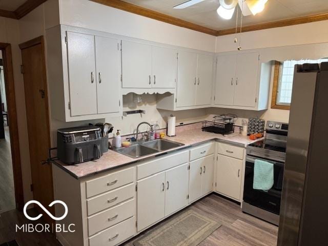 2830 Guilford Ave, Indianapolis, IN 46205 - kitchen with stainless steel appliances, crown molding, light countertops, light wood-style flooring, and a ceiling fan