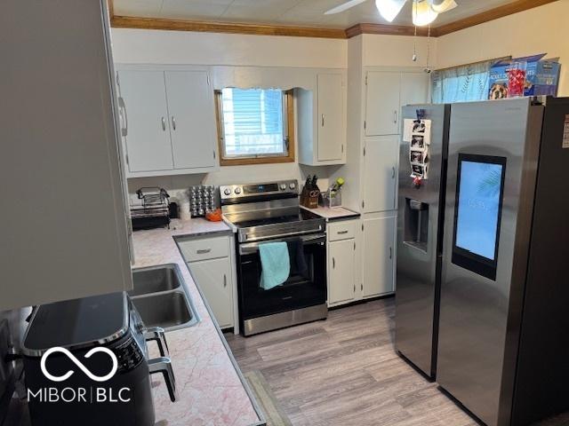 2830 Guilford Ave, Indianapolis, IN 46205 - kitchen featuring appliances with stainless steel finishes, ornamental molding, white cabinetry, light countertops, and a ceiling fan
