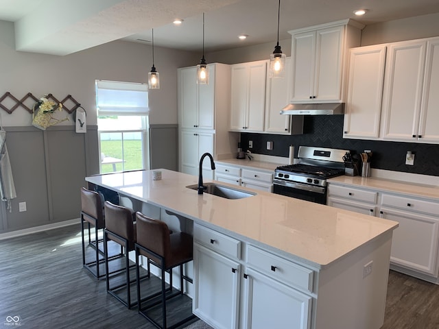 7270 W Stone Pass, New Palestine, IN 46163 - kitchen featuring stainless steel range with gas cooktop, under cabinet range hood, dark wood-style floors, white cabinets, and an island with sink