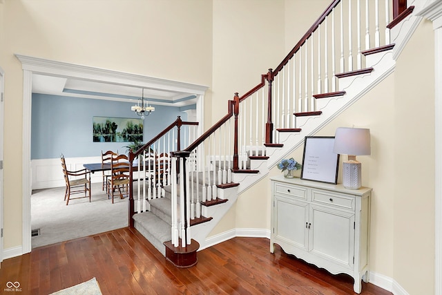 10587 Proposal Pointe Way, Fishers, IN 46040 - stairway with a chandelier, hardwood / wood-style floors, a raised ceiling, and wainscoting