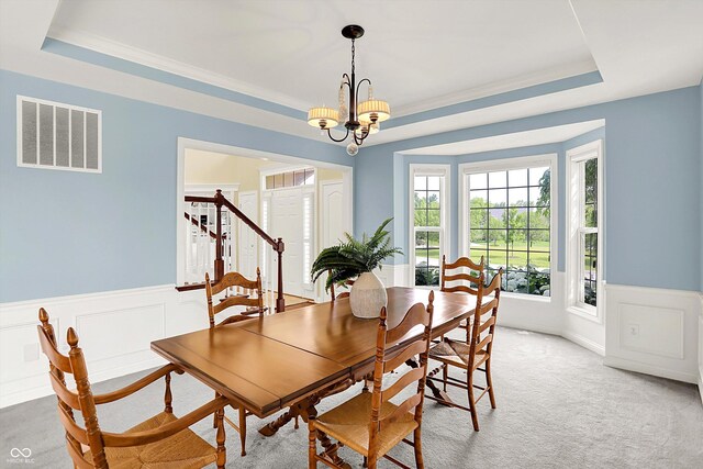 10587 Proposal Pointe Way, Fishers, IN 46040 - dining space with a raised ceiling, a chandelier, wainscoting, stairway, and light colored carpet