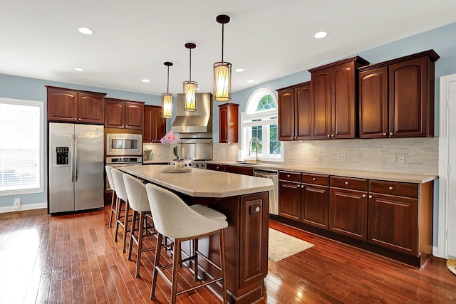 10587 Proposal Pointe Way, Fishers, IN 46040 - kitchen with stainless steel appliances, dark wood-type flooring, a breakfast bar, a center island, and pendant lighting