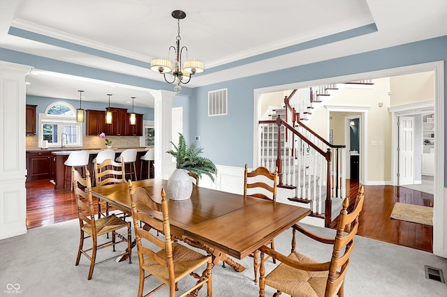10587 Proposal Pointe Way, Fishers, IN 46040 - dining space featuring decorative columns, a tray ceiling, stairway, and ornamental molding