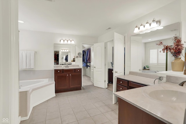 10587 Proposal Pointe Way, Fishers, IN 46040 - bathroom featuring two vanities, a bath, tile patterned floors, and a walk in closet