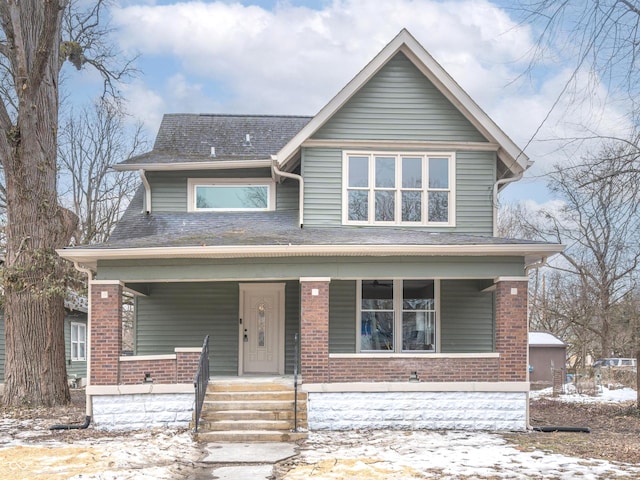 5511 E University Ave, Indianapolis, IN 46219 - view of front of house featuring covered porch, brick siding, and a shingled roof