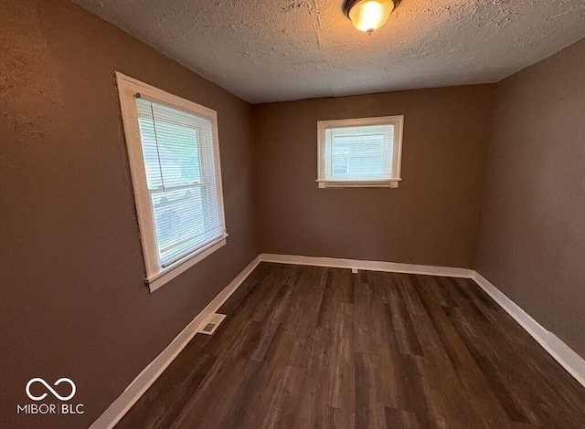 1521 N Tacoma Ave, Indianapolis, IN 46201 - empty room with dark wood finished floors, healthy amount of natural light, and a textured ceiling