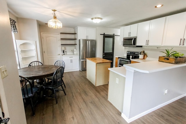 7710 Samuel Dr, Indianapolis, IN 46259 - kitchen with appliances with stainless steel finishes, wood counters, open shelves, a kitchen island, and wood finished floors