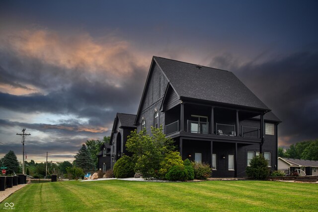 3306 Mullinix Rd, Greenwood, IN 46143 - back of property at dusk with a balcony, a yard, and a shingled roof