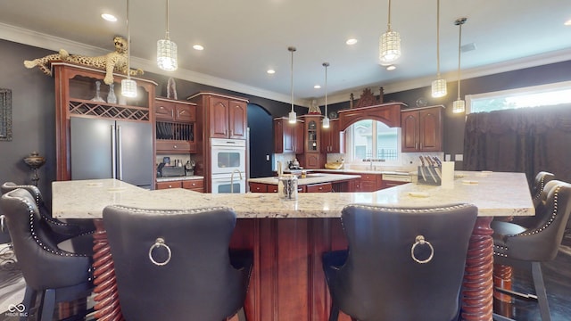 3306 Mullinix Rd, Greenwood, IN 46143 - kitchen with high end fridge, white double oven, a large island with sink, glass insert cabinets, and crown molding
