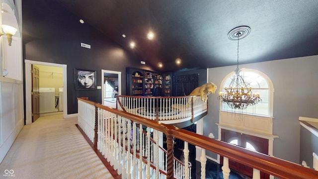 3306 Mullinix Rd, Greenwood, IN 46143 - hall with an upstairs landing, washer and dryer, a chandelier, high vaulted ceiling, and light colored carpet