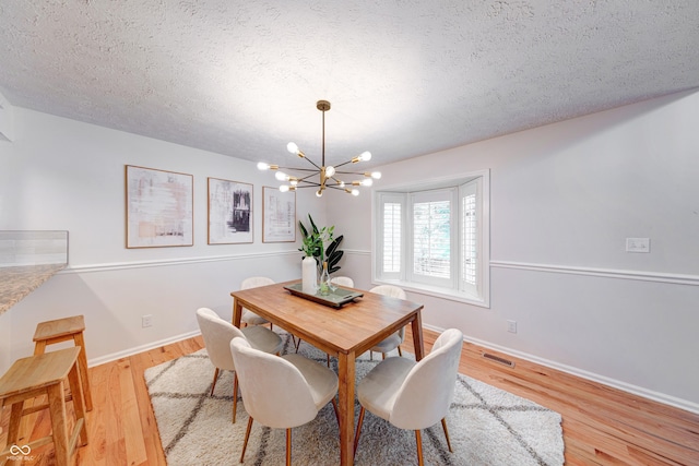 8178 Foxchase Cir, Indianapolis, IN 46256 - dining area featuring a chandelier, a textured ceiling, and light wood-style floors