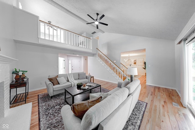 8178 Foxchase Cir, Indianapolis, IN 46256 - living area with stairs, a fireplace, ceiling fan, light wood finished floors, and high vaulted ceiling