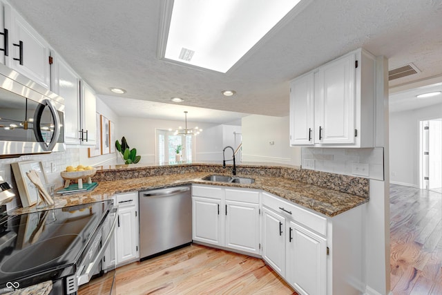 8178 Foxchase Cir, Indianapolis, IN 46256 - kitchen featuring stainless steel appliances, a chandelier, light wood-style floors, white cabinets, and recessed lighting
