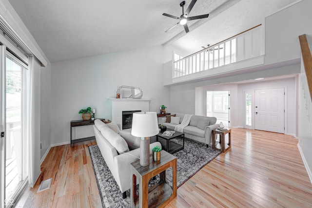 8178 Foxchase Cir, Indianapolis, IN 46256 - living room with a brick fireplace, plenty of natural light, lofted ceiling, ceiling fan, and light wood finished floors