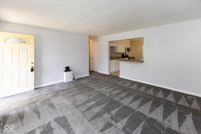 220 E Tilden Dr, Brownsburg, IN 46112 - unfurnished living room with dark carpet and baseboards