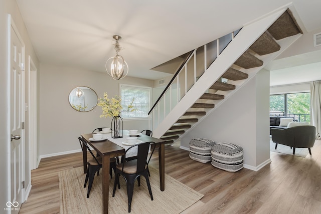 49 Druid Hill Ct Unit 0, Carmel, IN 46032 - dining room featuring light wood-style flooring, stairs, and a chandelier