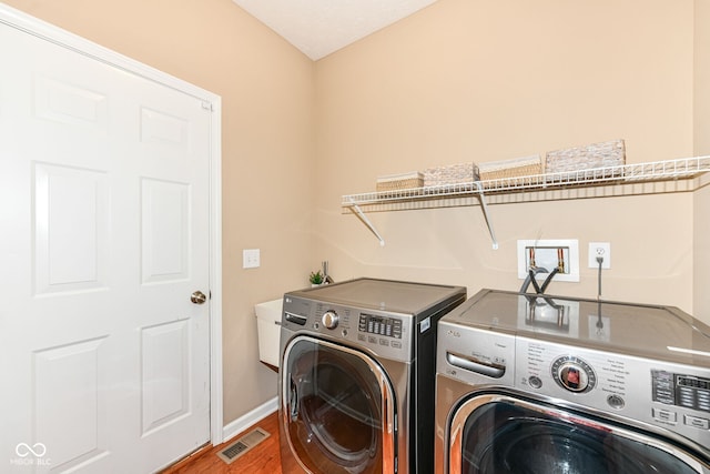 13700 Stanford Dr, Carmel, IN 46074 - laundry area with washing machine and clothes dryer and wood finished floors