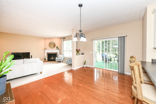 13700 Stanford Dr, Carmel, IN 46074 - living room with wood finished floors, a chandelier, a glass covered fireplace, and a textured ceiling