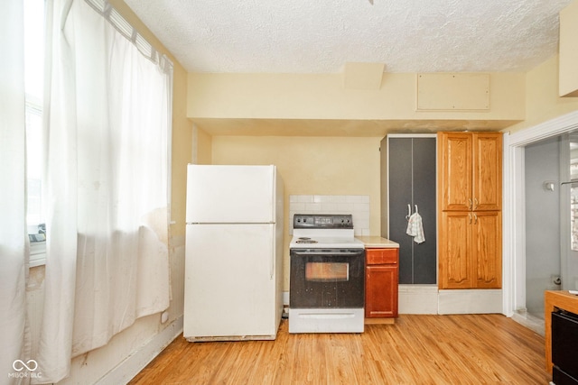 917 W 8th St, Anderson, IN 46016 - kitchen featuring white appliances, a textured ceiling, light wood-style floors, light countertops, and brown cabinetry