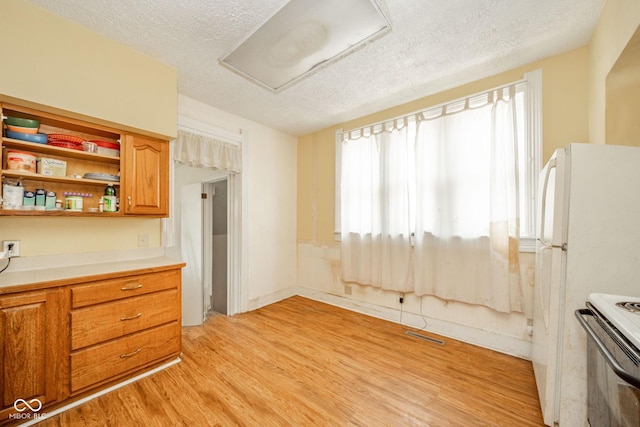 917 W 8th St, Anderson, IN 46016 - kitchen with a textured ceiling, light wood-type flooring, electric stove, light countertops, and brown cabinets