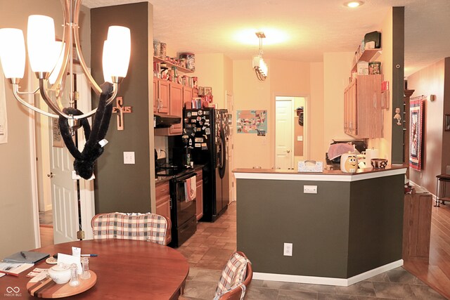 650 S Eagles Way, Crawfordsville, IN 47933 - kitchen with black appliances, under cabinet range hood, a peninsula, and a chandelier