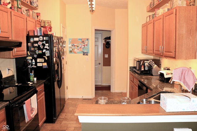 650 S Eagles Way, Crawfordsville, IN 47933 - kitchen with black appliances, range hood, dark countertops, light stone finish floors, and light brown cabinets
