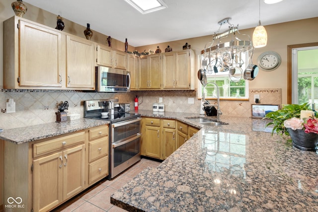 6439 Bower Dr, Indianapolis, IN 46241 - kitchen featuring stainless steel appliances, tasteful backsplash, a peninsula, light stone counters, and hanging light fixtures