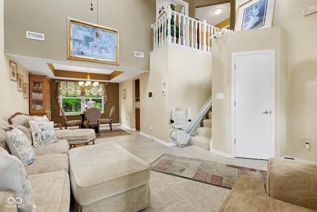 6439 Bower Dr, Indianapolis, IN 46241 - tiled living room featuring a chandelier, stairs, a high ceiling, and a tray ceiling