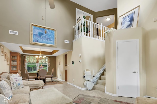 6439 Bower Dr, Indianapolis, IN 46241 - tiled living area featuring stairs, a chandelier, a high ceiling, and a ceiling fan
