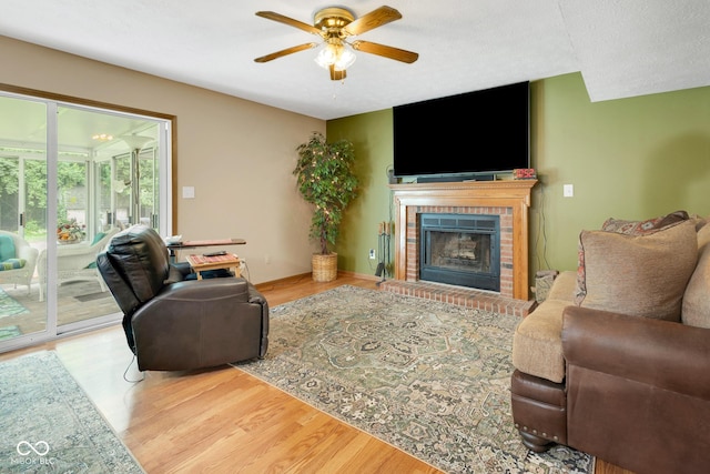 6439 Bower Dr, Indianapolis, IN 46241 - living area featuring a ceiling fan, wood finished floors, and a brick fireplace