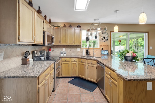 6439 Bower Dr, Indianapolis, IN 46241 - kitchen with appliances with stainless steel finishes, a peninsula, decorative backsplash, and light brown cabinets