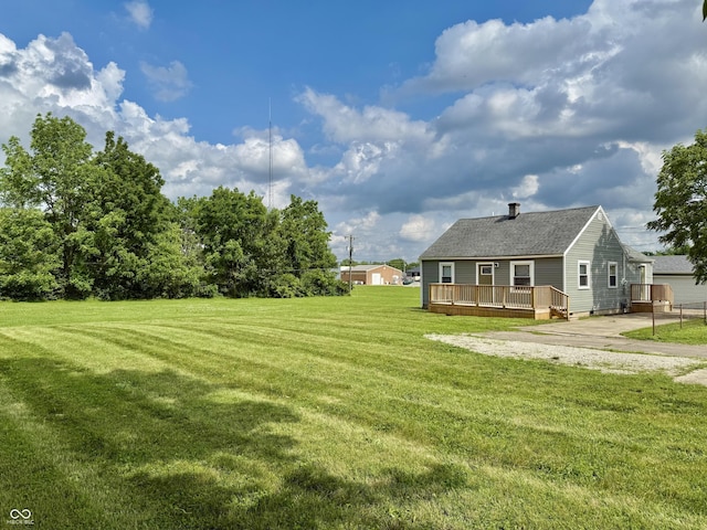 405 E Cowing Dr, Muncie, IN 47303 - view of green lawn with a deck and concrete driveway