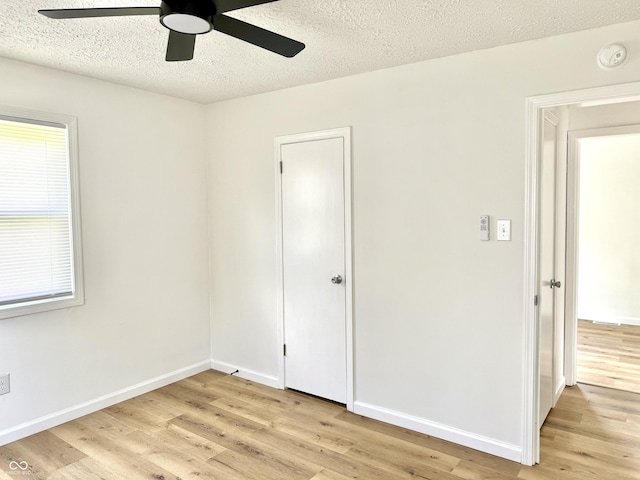 405 E Cowing Dr, Muncie, IN 47303 - unfurnished bedroom with light wood-style floors, a textured ceiling, and a ceiling fan