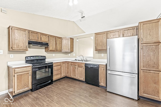 1540 Brook Pointe Dr, Indianapolis, IN 46234 - kitchen with black appliances, under cabinet range hood, lofted ceiling, light countertops, and wood finished floors
