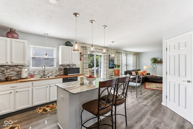 6711 Crestwell Ln, Indianapolis, IN 46268 - kitchen featuring black appliances, decorative backsplash, wood finished floors, a textured ceiling, and white cabinetry