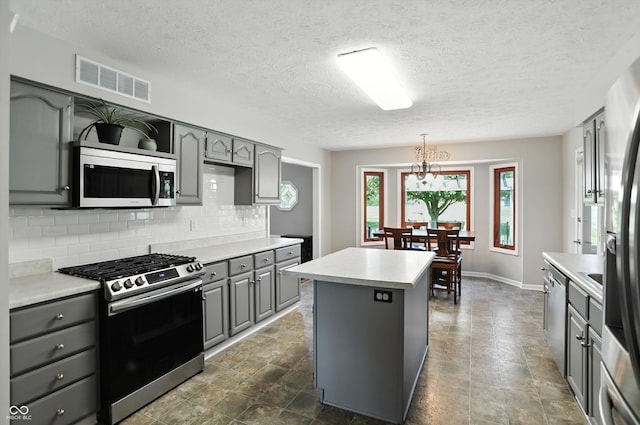 8030 5 Points Rd, Indianapolis, IN 46259 - kitchen featuring stainless steel appliances, gray cabinets, decorative backsplash, a kitchen island, and light countertops