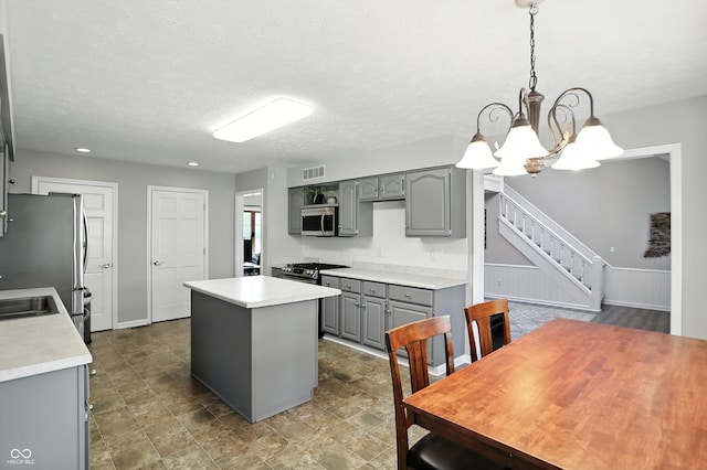 8030 5 Points Rd, Indianapolis, IN 46259 - kitchen featuring gray cabinetry, appliances with stainless steel finishes, a center island, a chandelier, and light countertops