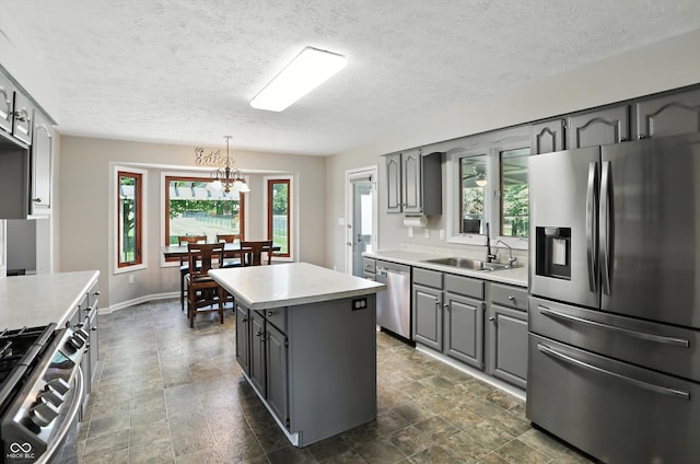 8030 5 Points Rd, Indianapolis, IN 46259 - kitchen with appliances with stainless steel finishes, gray cabinetry, light countertops, a kitchen island, and a textured ceiling