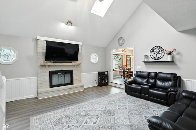 8030 5 Points Rd, Indianapolis, IN 46259 - living room with wood finished floors, a wainscoted wall, a skylight, a fireplace, and high vaulted ceiling