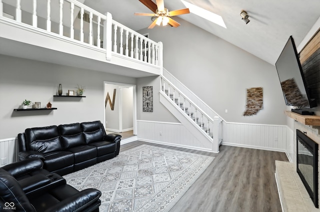 8030 5 Points Rd, Indianapolis, IN 46259 - living area with high vaulted ceiling, wainscoting, a fireplace, wood finished floors, and a skylight
