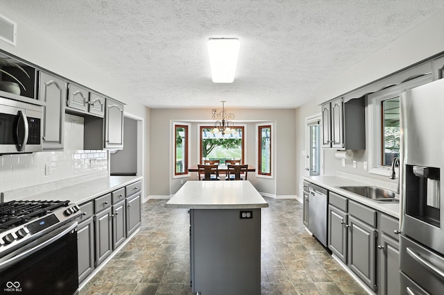 8030 5 Points Rd, Indianapolis, IN 46259 - kitchen featuring gray cabinets, appliances with stainless steel finishes, a kitchen island, dark stone finish floors, and backsplash