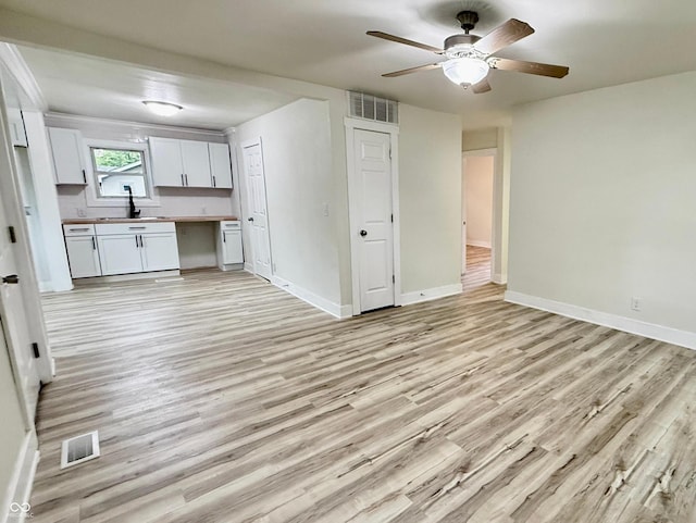 3712 S Kealing Ave S, Indianapolis, IN 46237 - kitchen featuring light wood finished floors, open floor plan, ceiling fan, white cabinets, and light countertops